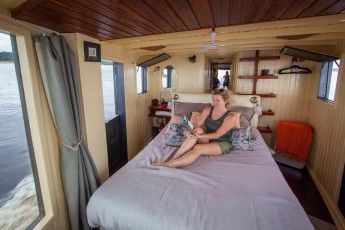 Hayley has made herself comfortable with a book in the bow cabin of our Amazonas boat.