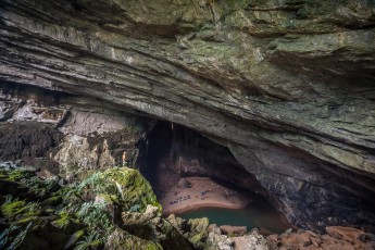 Unser erstes Nachtlager - vom Eingang der Hang En Cave aus gesehen. Das, was wie kleine Farbpunkte anmutet, sind unsere Ein- und Zweimannzelte. Zum weiteren Größenvergleich: Auf dem grünen Absatz etwas links von der Mitte steht ein Expeditions-Assistent.