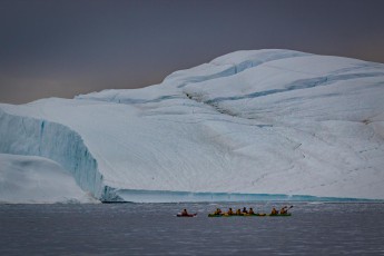 Guests of One Ocean Expedition explore the Illulisat Icefjord in kayaks.