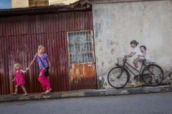Amelie and Smilla on the run. But it's all an act. Because the bike is real, but the two brats on the right are only painted on the wall (Georgetown, Malaysia).