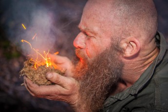Bruce demonstriert, wie man mit Holz, Elefantendung, Geschick und Geduld Feuer entfacht.