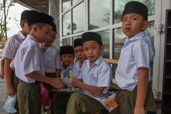 Brunei Schuljungen, die heimlich mit Aufklebern handeln.

