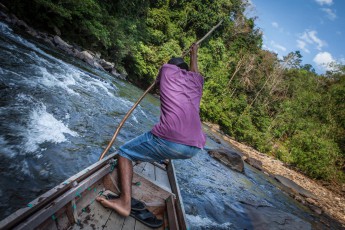 A WWF boat takes two teachers and me to the last village close to the source of the river. The boat gets stuck constantly and this man heaves us over the flat spots on an on again. What a grind work.