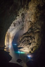 Von meinem Standpunkt blicke ich 600 Meter weit bis zum Ende der Son Doong Höhle. Etwa 30 Meter oberhalb der Boote erkennt man einen weißen Schleier: Wolken! Die Höhle verfügt über ein eigenes Klima! Immer wieder marschieren wir durch plötzlich auftauchende 'Dampfbäder', die sich dann als Wolken entpuppen. Am Höhlenende müsste man noch die 200 Meter hohe, sehr rutschige 'Große Mauer von Vietnam' überwinden und sich dann durch knietiefen Schlamm quälen, um zum Hinterausgang der Höhle zu gelangen. Da das definitiv zu gefährlich und kräfteraubend ist, paddeln meine 'Cavemates' und ich mit Booten über den See, bevor wir uns auf den Eineinhalb-Tagesmarsch zurück zum Eingang machen.
