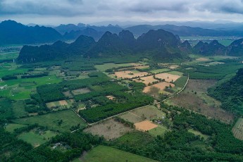 Reis- und Gemüseanbaufelder bei Phong Nha.  Die Region gehört zu den schnell wachsenden Touristendestinationen Südostasiens. Das liegt unter anderem an den leicht zugänglichen und prächtigen Schauhöhlen Phong Nha Cave und Paradise Cave. Bis heute hat man in der Umgebung über 230 Höhlen entdeckt und vermessen. Viele weitere werden noch in den abseits gelegenen Arealen des Nationalparks vermutet.

