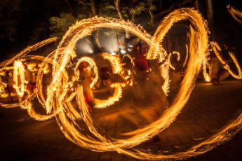 Whip crackers and fireball acrobats clear the way, followed by the Buddhist flag bearers.
