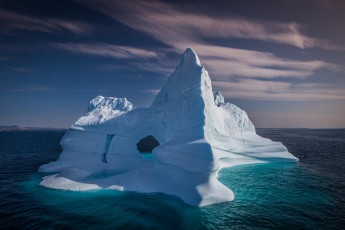 Grönland: Permanente Wellen können vorhandene Risse im Eisberg derart abnutzen, dass dadurch große Löcher entstehen - so wie bei diesem Eisberg.