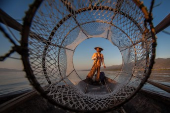 Burma/Myanmar: Ein Fischer auf dem Inle See, Burma. Die Intha, die 'Söhne des Sees', wie sie sich selbst nennen, kennen 15 verschiedene Fischfangmethoden. Unter anderen nutzen sie federballförmige Netze wie auf dem Bild.