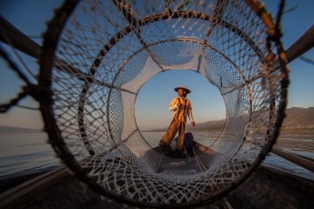 Burma/Myanmar: A fisherman on Inle Lake, Burma. The Intha, the 'sons of the lake', as they call themselves, know 15 different fishing methods. Among others, they use featherball-shaped nets like the one in the picture.