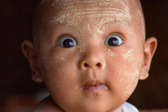 Burma/Myanmar: Ein neugieriger wie erstaunter Junge. Die gelbliche Thanakapaste dient als Hautpflege und Sonnenschutz.