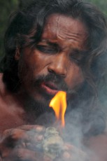 Guna Bandiya ignites fire with a fire stone and a ball of cloth.