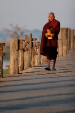 Burma/Myanmar, Amarapura, U-Bein Bridge: A monk on his way back from the morning's alms walk.
 