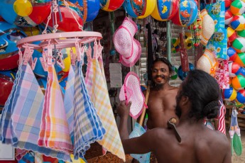 GunaBandiya and his neighbor sneer at the displayed goods of a shop.