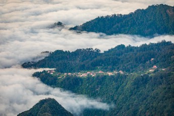 Blick von der Wanderroute Vereda do Arieiro auf eine Küstensiedling im Nordosten.