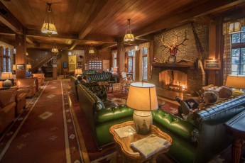 The rustic lodge from 1926 offers a majestic fireplace, rocking chairs and deep leather fauteuils in its lobby.