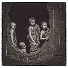 Novices curiously looking outside of their wooden monastery near Inle Lake. 
