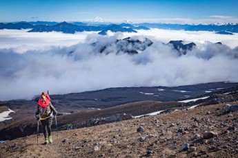 Chile: Während unseres Aufstiegs auf den Vulkan Villarrica werden wir mit fantastischen Ausblicken über die wolkenverhangene Landschaft und den Vulkan Llaima belohnt.
