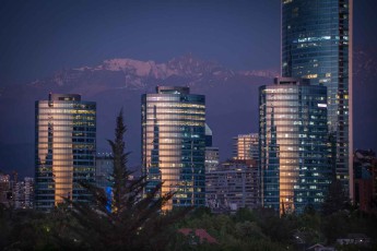 Fantastische Lichtspiele des Lichts der untergehenden Sonne auf Andenausläufern im Hintegrund und den Hochhäusern von Santiago de Chile.
