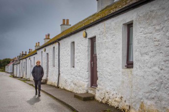 Annette spaziert entlang der historischen, weißgetünchten Cottages auf der Insel Coll.