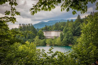 Through the lush green canopy of chestnuts and beeches, Villa Bled gleams in classical splendour - once the president's summer residence, now a luxury hotel on the shores of the emerald glacial lake.