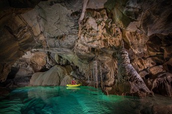 Gašper Modic glides through one of the emerald green lakes of Križna Cave in a yellow rubber dinghy. The 8,273-metre-long water cave is home to 22 underground lakes and is considered one of the most beautiful stalactite caves in Europe.