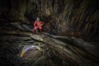 The Reka River rushes over polished limestone banks through the depths of the Škocjan Cave. Guide Borut Lozej examines a basin that has been shaped by thousands of years of water power and erosion.