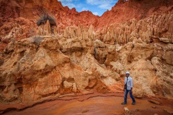 Unser Guide Christian wandelt in einem Bachbett von Tsingy Rouge. Diese bizarren Gesteinsformationen aus rotem Laterit entstanden durch Erosion.