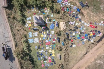 Wie ein buntes Puzzle aus Textilien breitet sich eine Großwäscherei unter freiem Himmel bei Antananarivo aus - aus der Vogelperspektive wird die traditionelle madagassische Art des Wäschetrocknens zu einem farbenfrohen Mosaik, bei dem unzählige Kleidungsstücke ordentlich auf der Wiese ausgelegt werden, um in der tropischen Sonne zu trocknen.