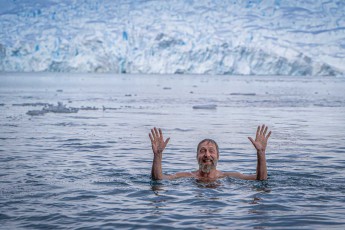 Breites Grinsen – der Polar Plunge ist geschafft! Hinter mir türmt sich die Gletscherwand, unter mir kribbelt jede Faser. Ein Moment purer Euphorie im eisigen Südpolarmeer. (Foto von Carlos Chercoles, Swan Hellenic)